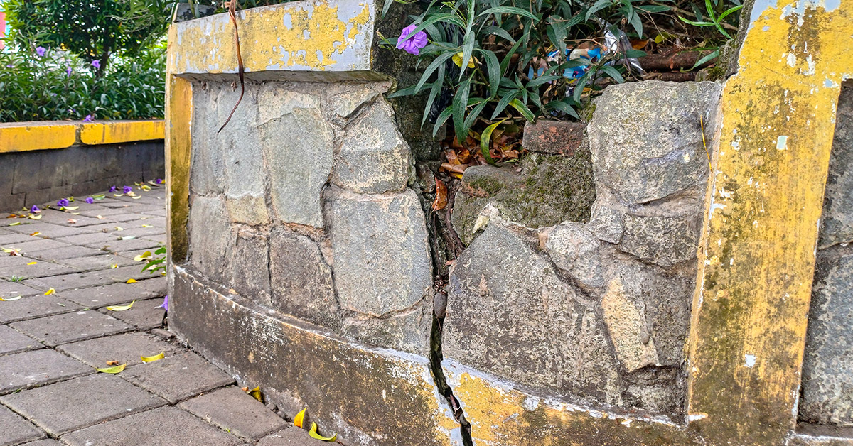 Failing retaining wall in Massachusetts beside an older residential property